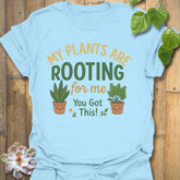Light Blue t-shirt featuring the design Plants Are Rooting printed in bold letters, gardening graphic tee.