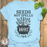 Light Blue t-shirt featuring the design Seeds Not Spells printed in bold letters, halloween plant lover shirt.