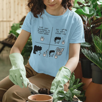 Light Blue t-shirt featuring the design “The say speaking to plants help them grow so I speak to mine everyday” with a funny character of a man and plants printed in bold colours