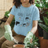 Light Blue t-shirt featuring the design “The say speaking to plants help them grow so I speak to mine everyday” with a funny character of a man and plants printed in bold colours