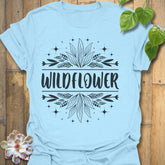 Light Blue t-shirt featuring the design Wildflower printed in bold white letters, floral graphic shirt.