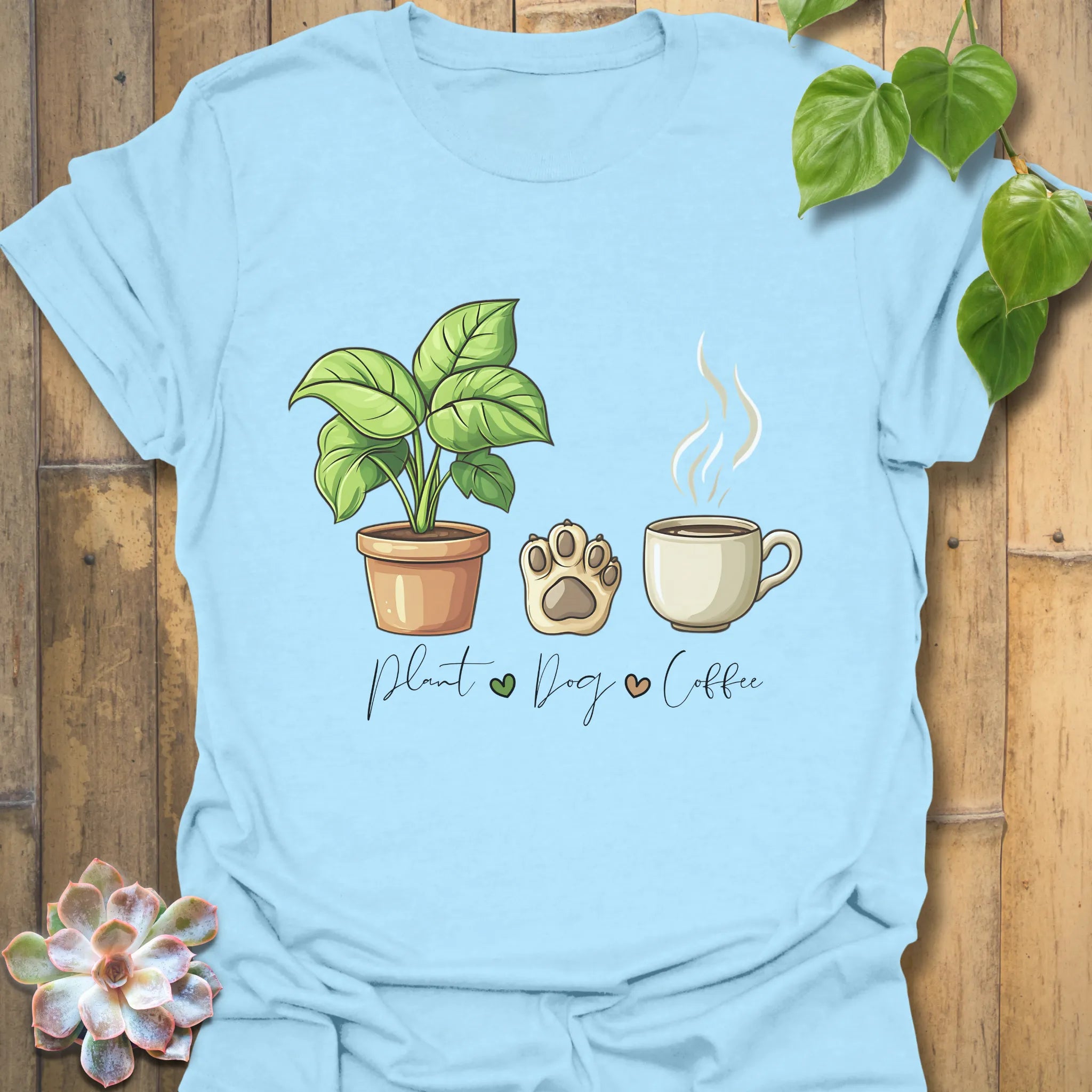 Light Blue t-shirt with “Plant, Dog, Coffee” lettering – soft casual shirt for coffee lovers and plant enthusiasts.