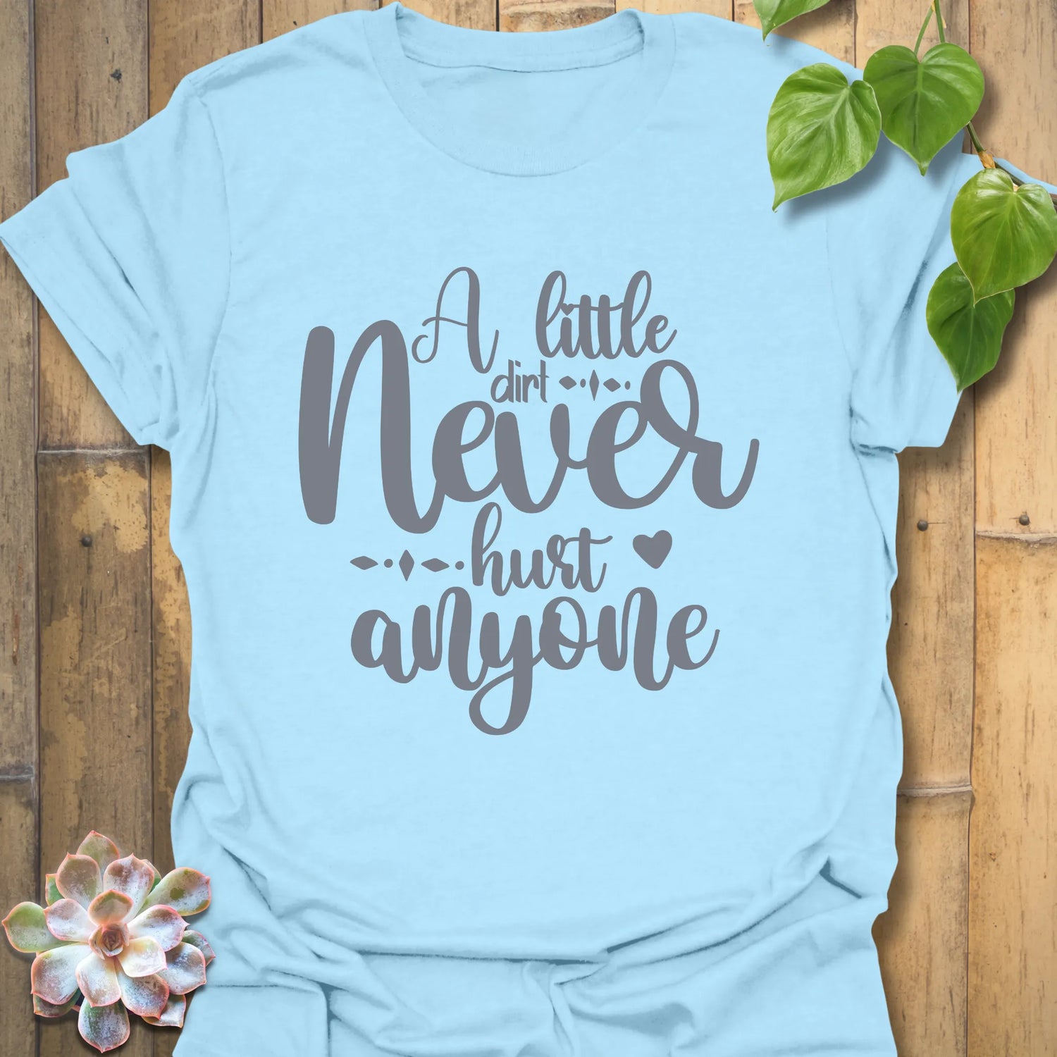 Light blue funny garden shirt with the phrase A Little Dirt Never Hurt Anyone in playful lettering.