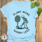 Light blue t-shirt featuring the design Plant More Worry Less with a skeleton and plant character, soft cotton eco-friendly shirt.
