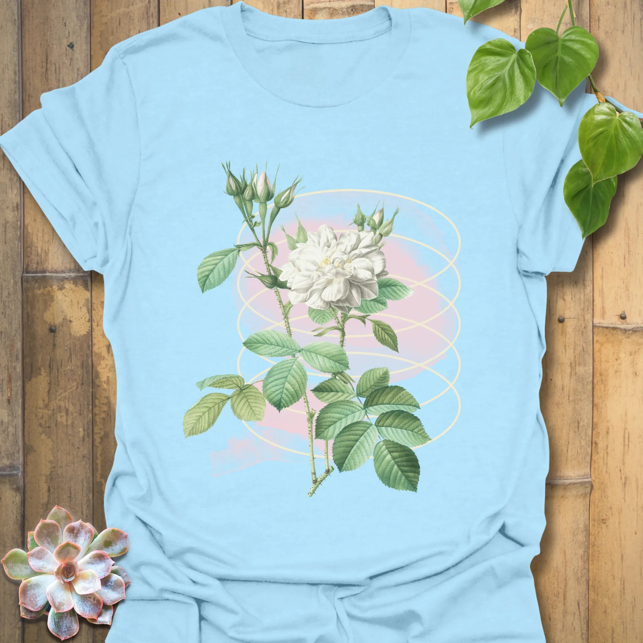 Light blue t-shirt with the Blossom Whisper design featuring a soft flower illustration
