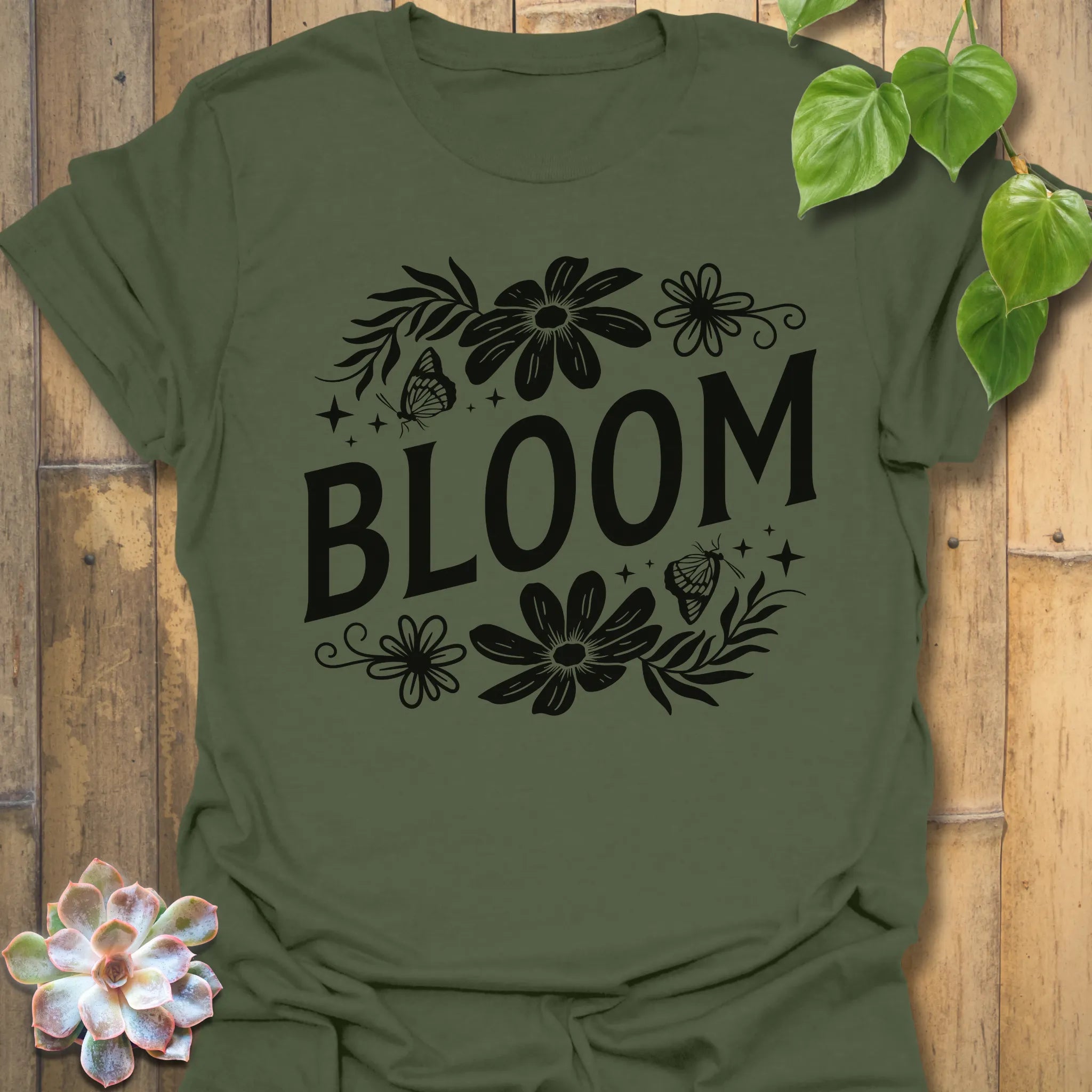 Military Green t-shirt featuring the design Bloom printed in bold black letters, floral graphic tee for plant lovers.