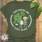 Military Green t-shirt featuring the design Feel Alive printed in bold white letters with plants, motivational graphic tee.