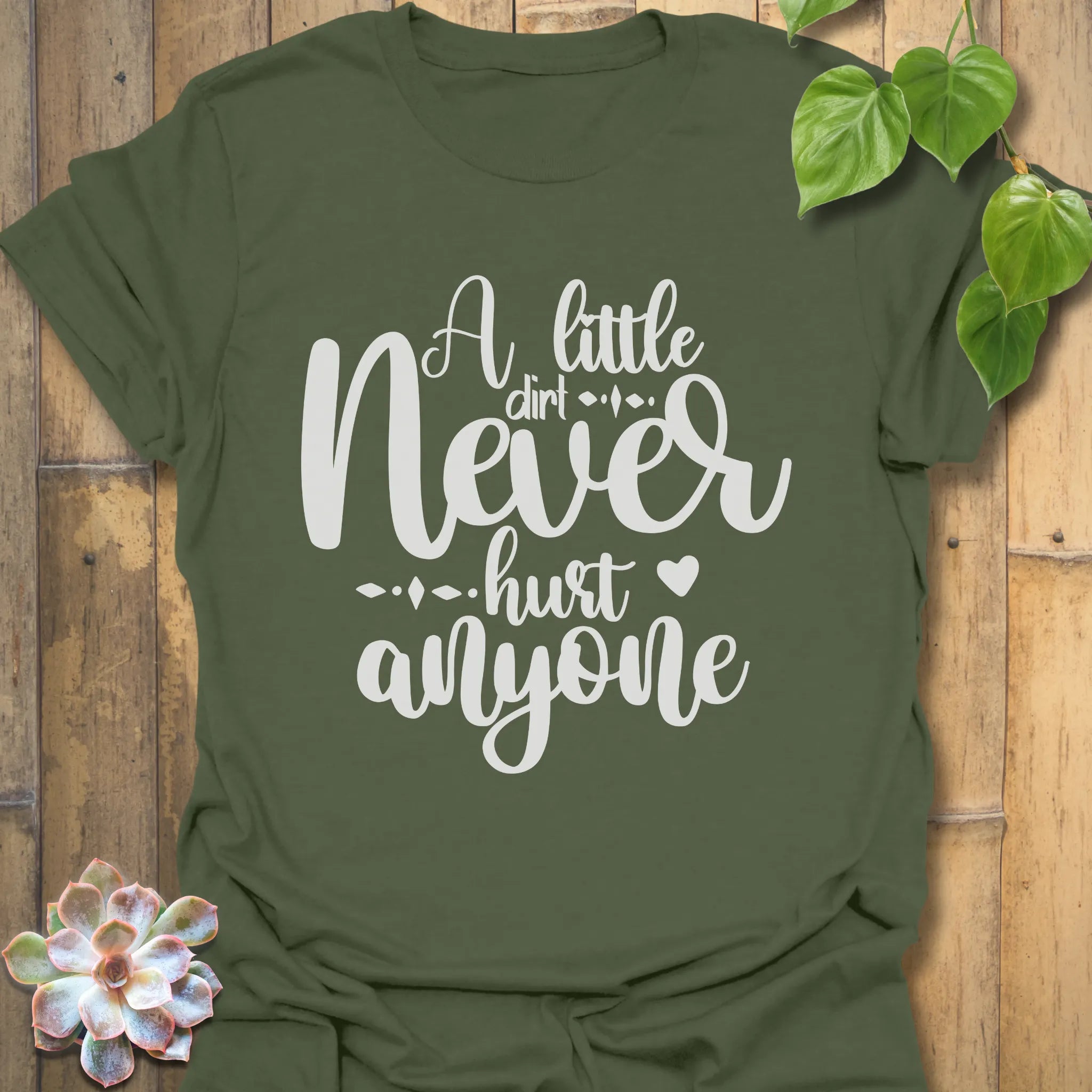Military green gardening t-shirt with the phrase A Little Dirt Never Hurt Anyone printed in outdoor-themed text.