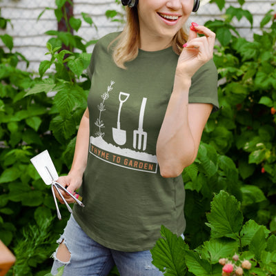 Military green t-shirt featuring the design &quot;Thyme To Garden&quot; with garden tool artwork, a stylish choice for gardeners and outdoor hobbyists.