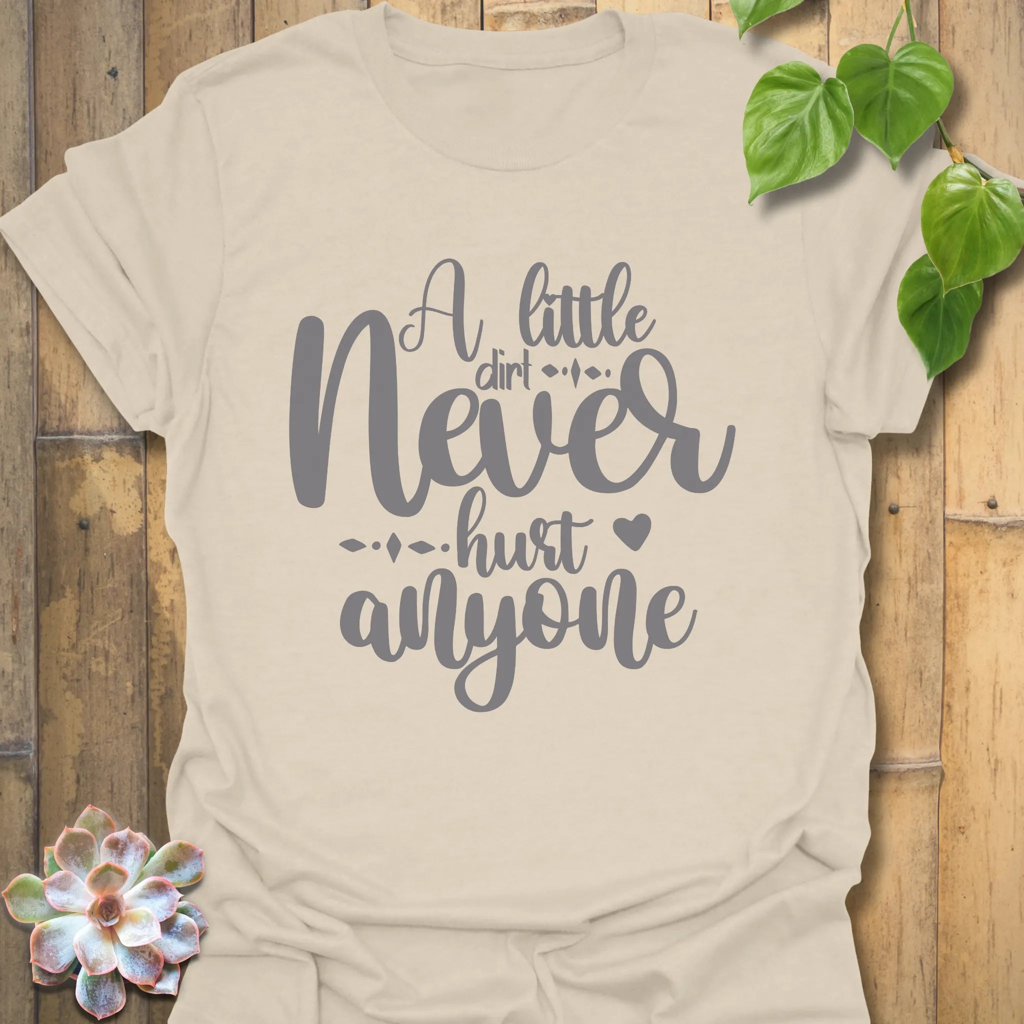 Natural organic cotton garden shirt featuring the design A Little Dirt Never Hurt Anyone in rustic style lettering.