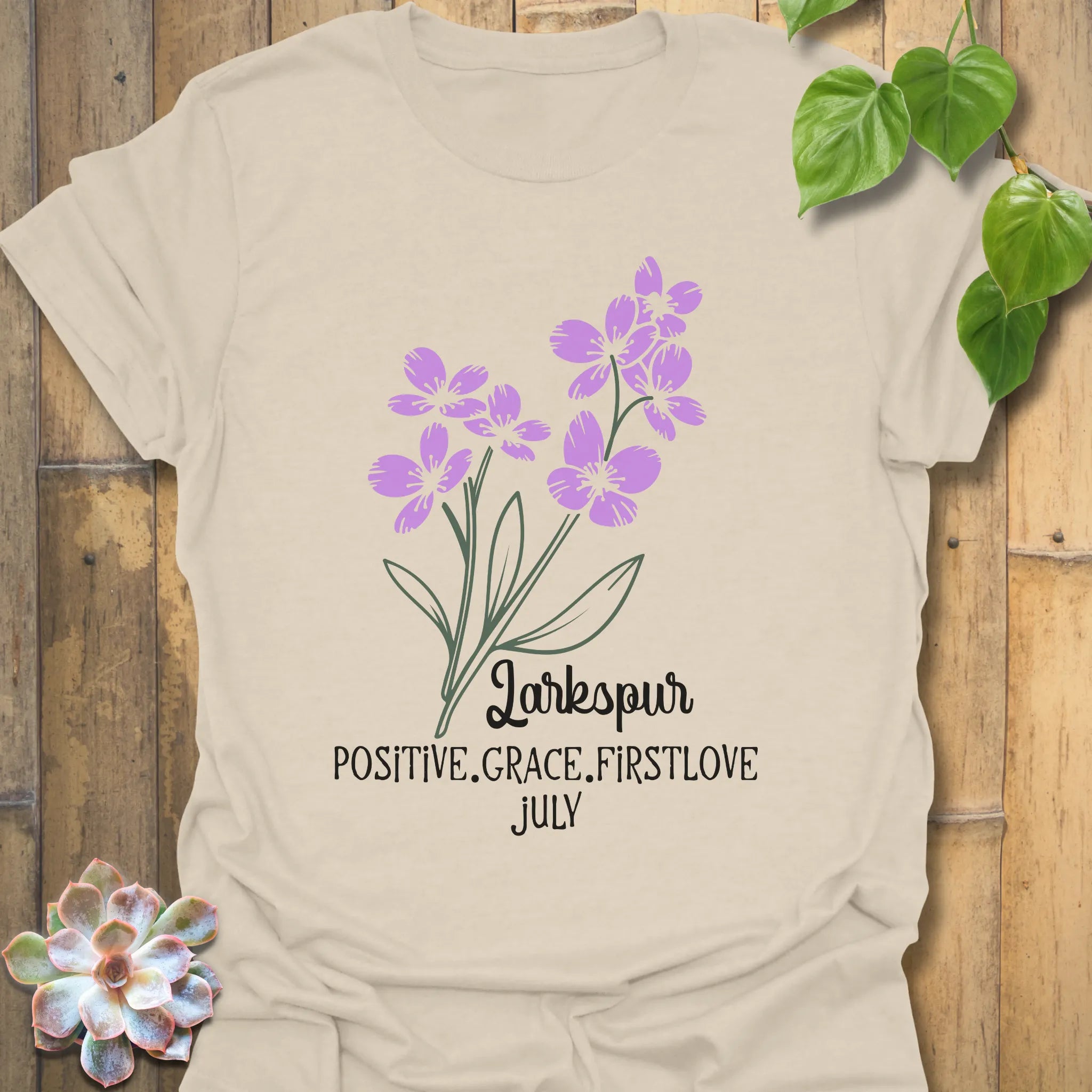 Natural t-shirt featuring the design July Larkspur with a detailed larkspur flower illustration, ideal as a floral botanical tee for nature and flower print shirt collections.