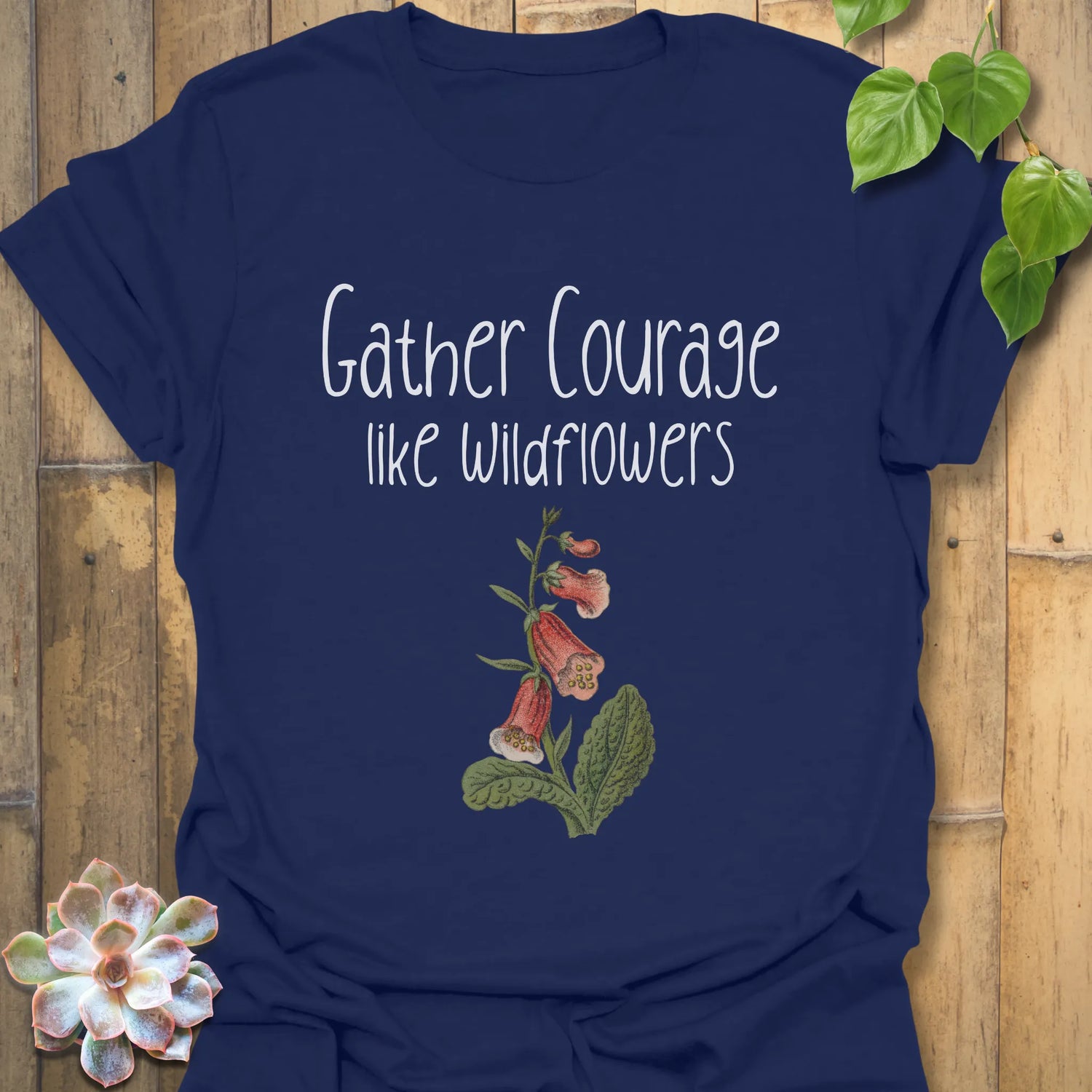 Navy botanical graphic t-shirt with the motivational words ‘Gather courage like wildflowers’ and an elegant flower illustration