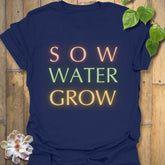 Navy t-shirt featuring the design Sow Water Grow printed with a floral garden artwork.