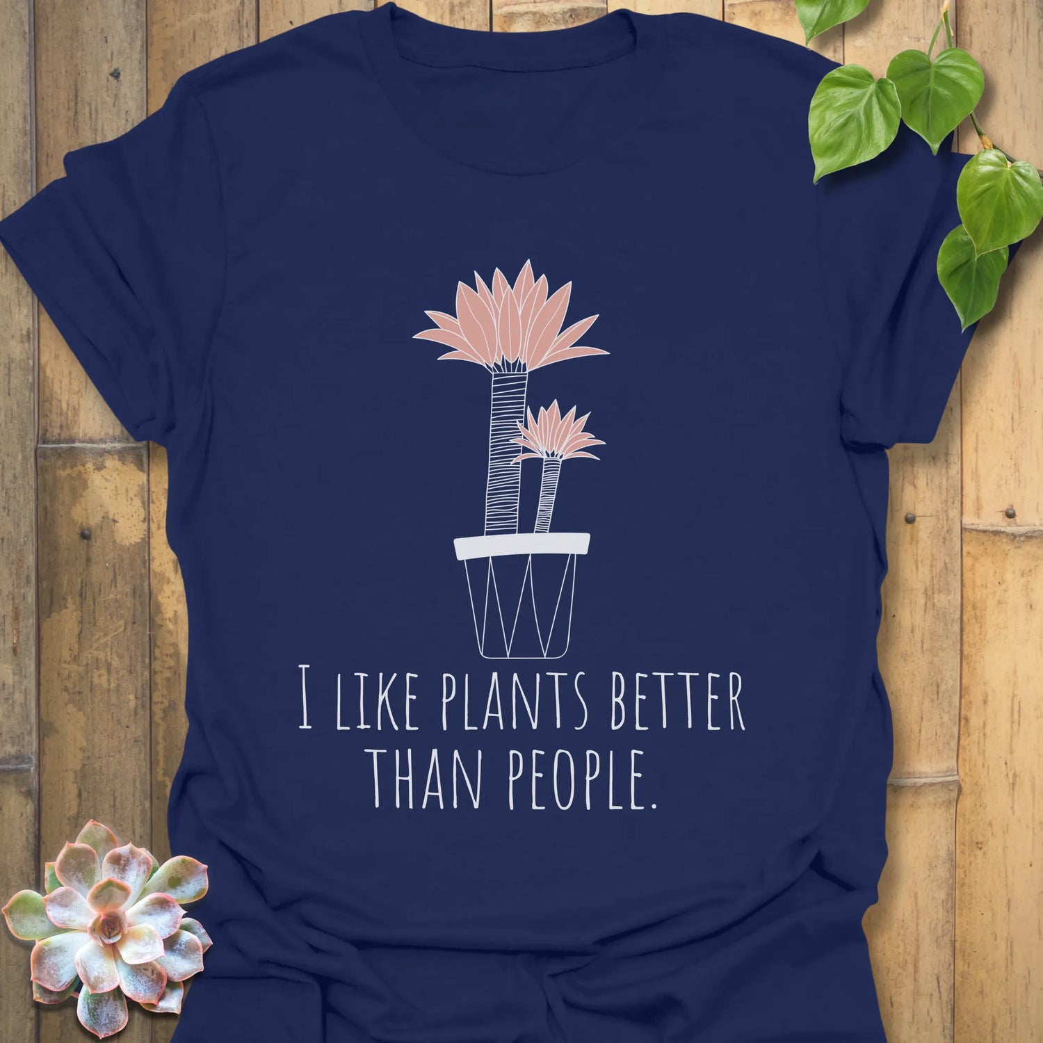 Navy t-shirt showing the phrase “I like plants better than people” alongside a flower in a pot print