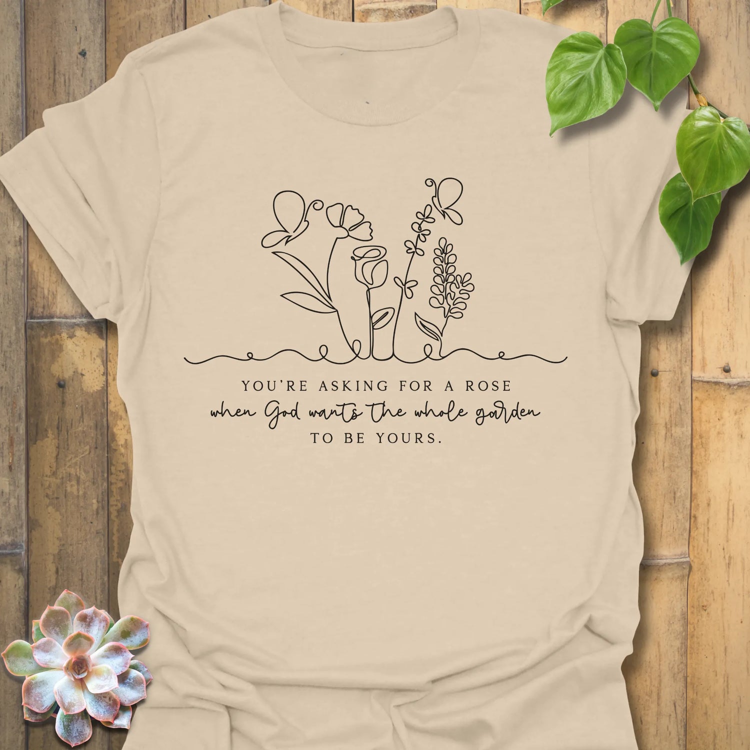Sand t-shirt featuring the design Asking For A Rose printed in black letters and flowers, floral humour shirt.