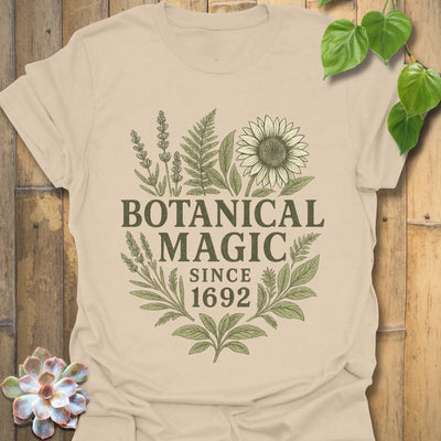 Sand t-shirt featuring the design Botanical Magic printed in bold letters, floral graphic tee.