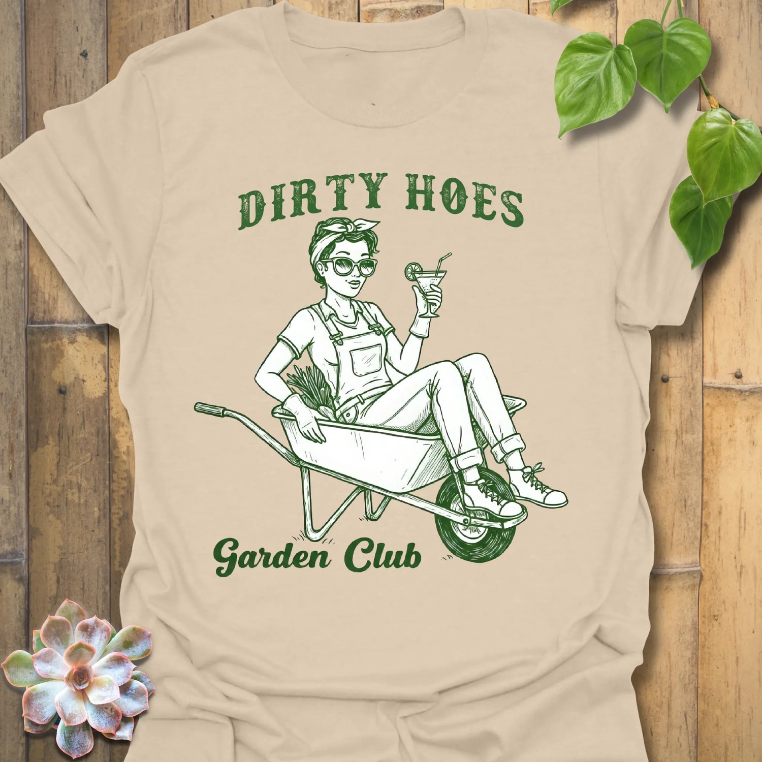 Sand t-shirt featuring the design Garden Club printed in bold green letters, garden lover t-shirt.