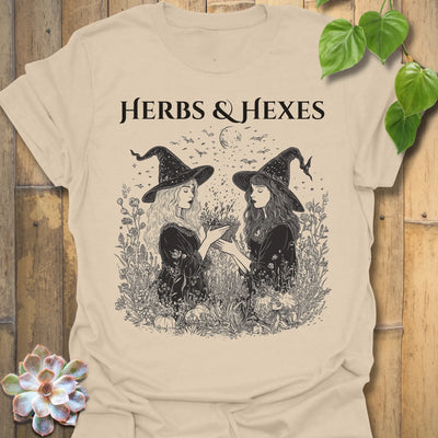 Sand t-shirt featuring the design Herbs &amp; Hexes printed in bold black letters, botanical witch t-shirt.