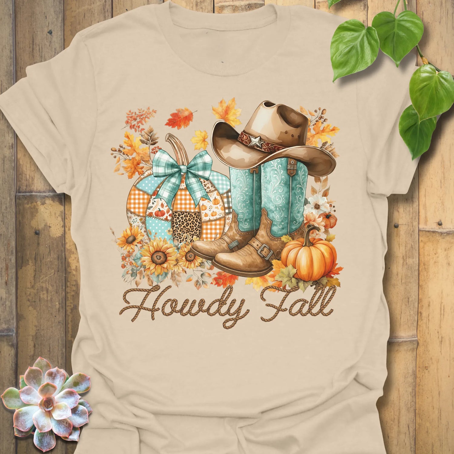 Sand t-shirt featuring the design Howdy Fall printed in brown letters, cute fall aesthetic shirt.