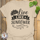Sand t-shirt featuring the design Live Like A Sunflower printed in bold black letters, sunflower lover shirt.