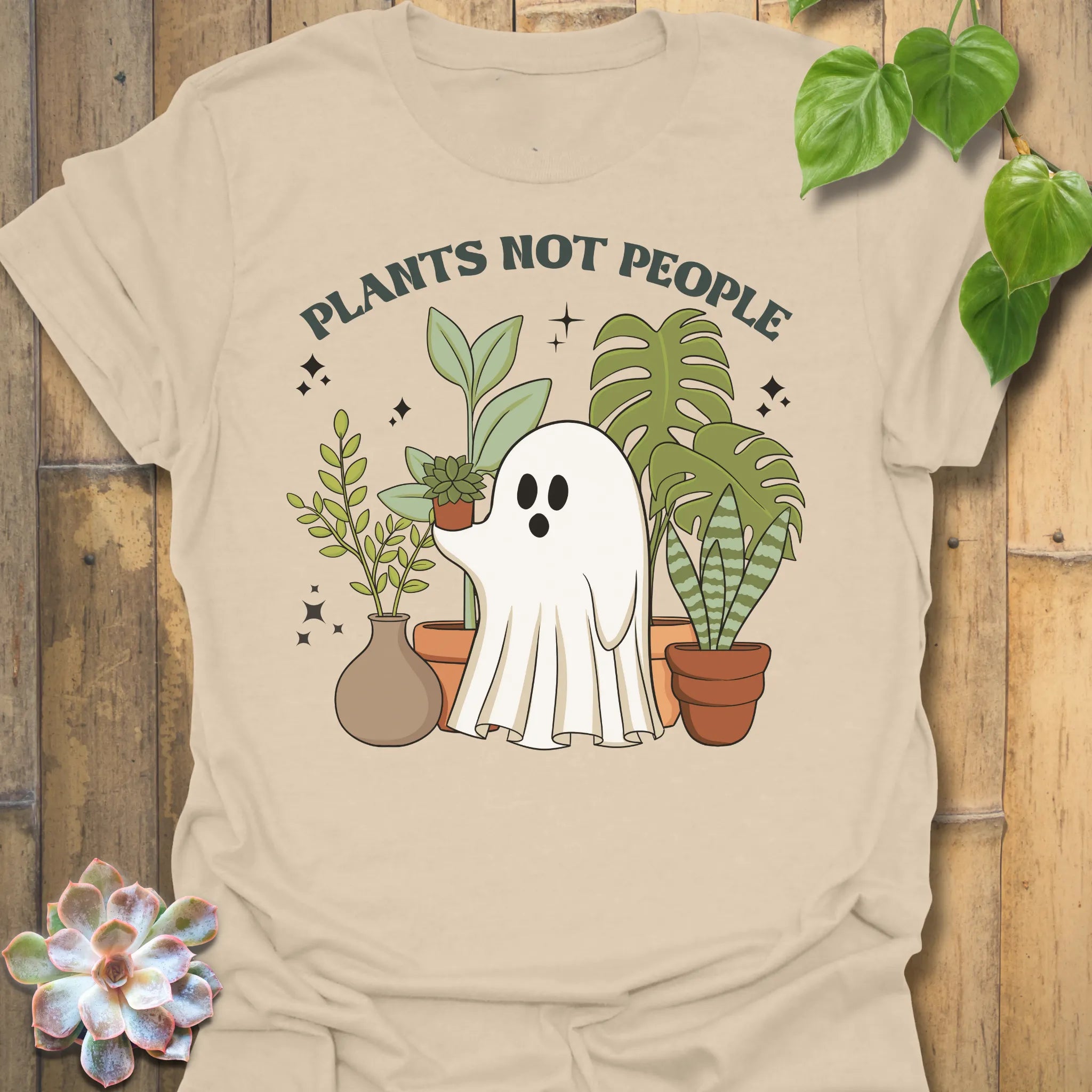 Sand t-shirt featuring the design Plants Not People printed in bold white letters, halloween plant lover graphic tee.