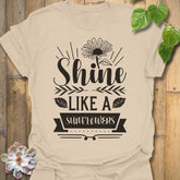 Sand t-shirt featuring the design Shine Like A Sunflower printed in bold letters, sunflower lover shirt.