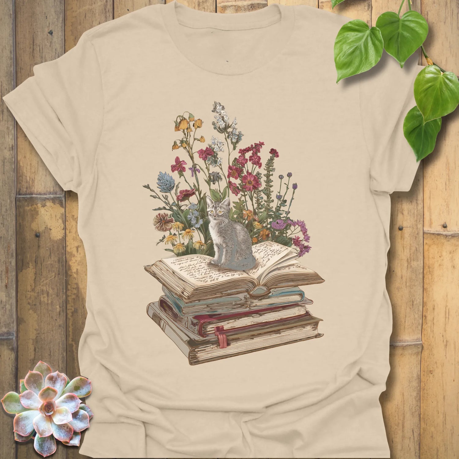 Sand t-shirt featuring the design Whiskers &amp; Words printed in books and cats with flowers, cat lover reading shirt.