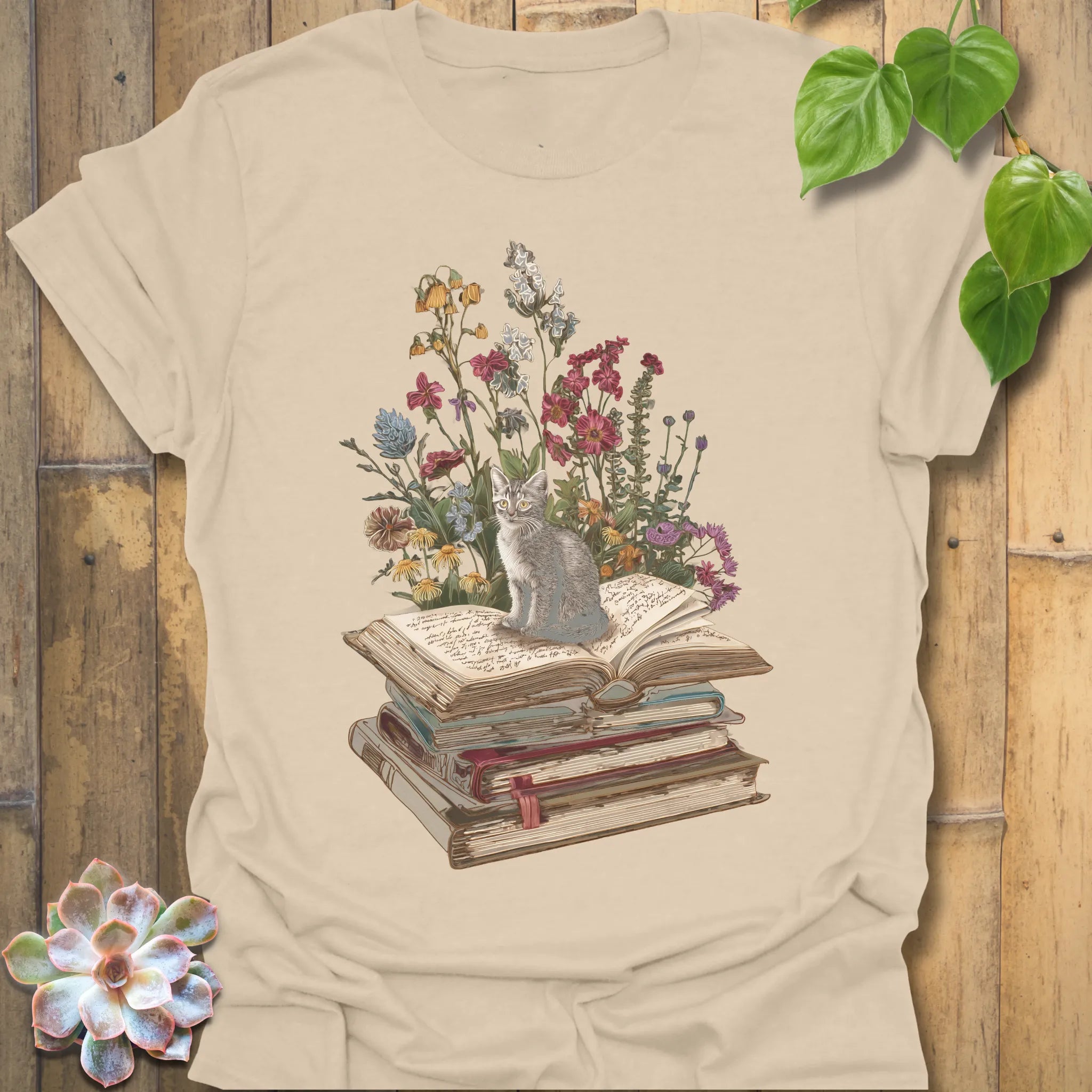 Sand t-shirt featuring the design Whiskers &amp; Words printed in books and cats with flowers, cat lover reading shirt.