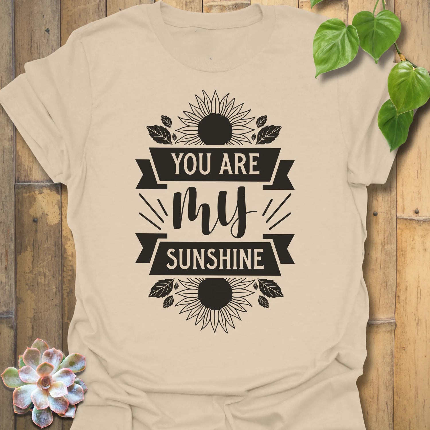 Sand t-shirt featuring the design You Are My Sunshine printed in bold letters, nature-inspired graphic tee.