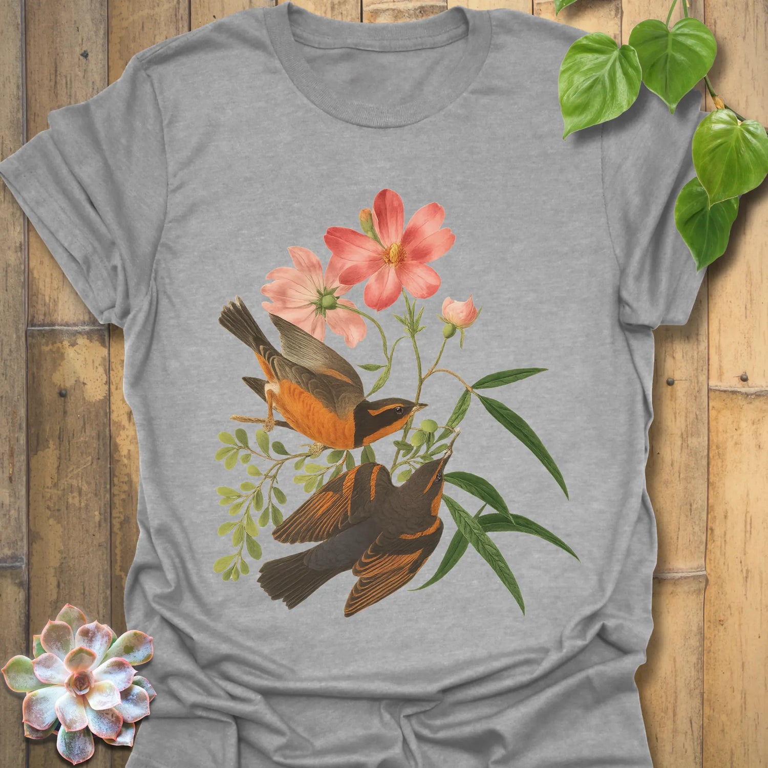 Sport grey t-shirt displaying the Spring Songbirds design of two perched birds with pink flowers and green leaves.