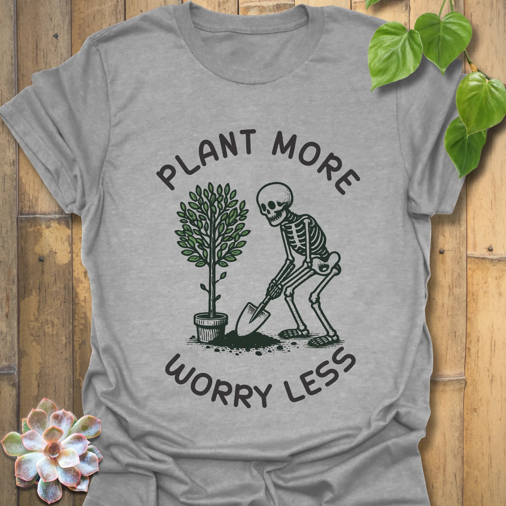 Sport grey t-shirt featuring the design Plant More Worry Less with plants and skeleton artwork, sustainable everyday graphic tee