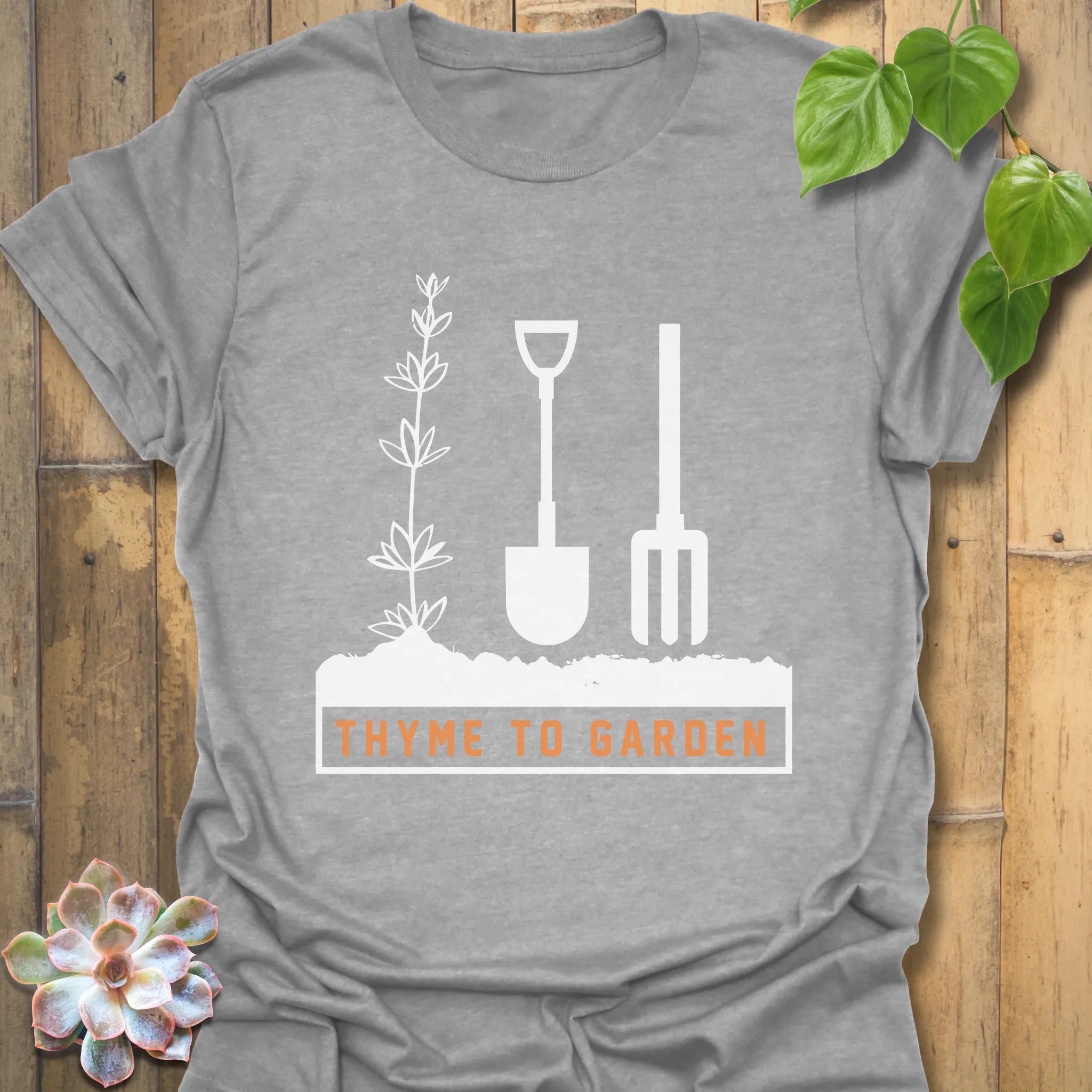 Sport grey t-shirt featuring the design &quot;Thyme To Garden&quot; with printed gardening tools, a versatile unisex shirt for garden and nature fans.