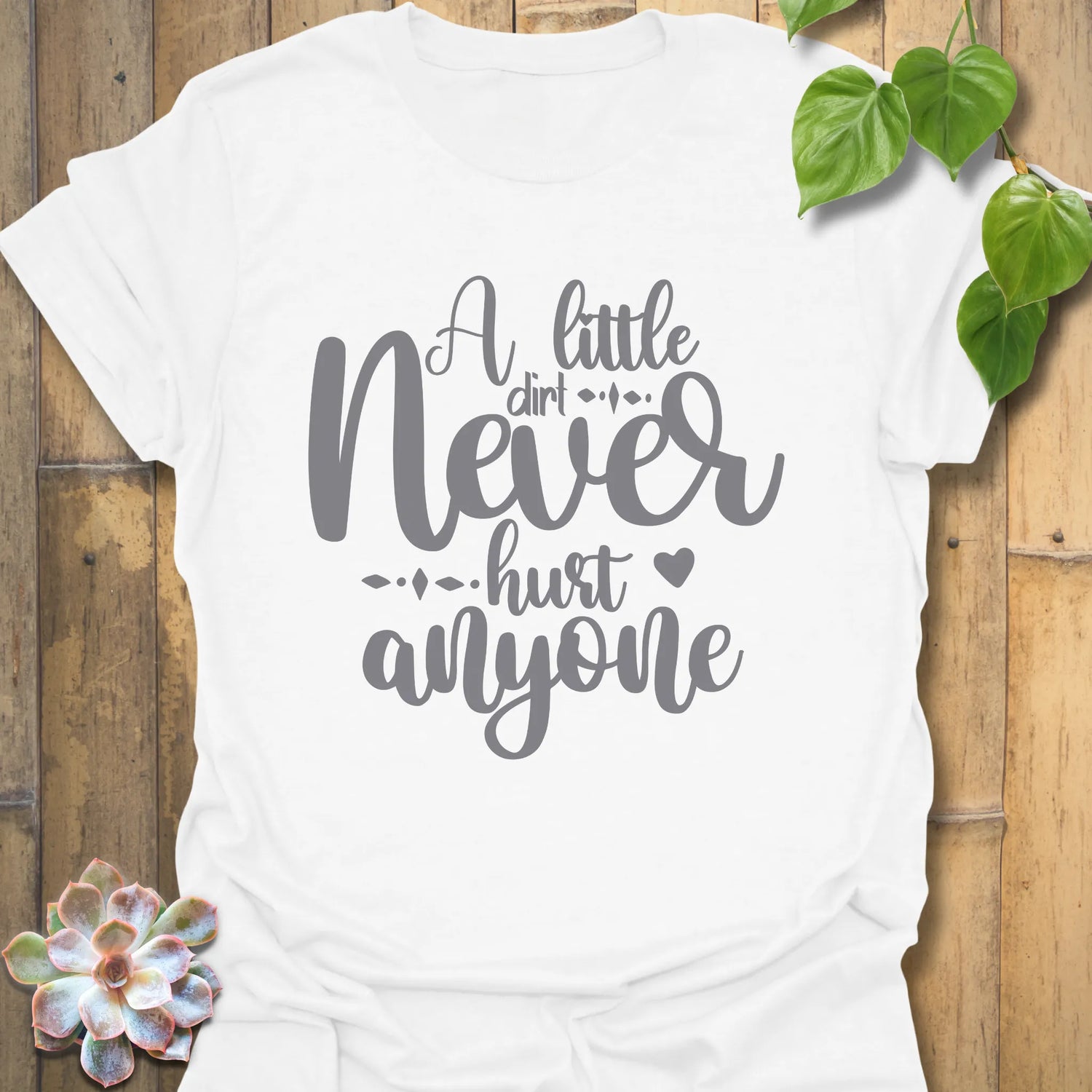 White gardening t-shirt featuring the design A Little Dirt Never Hurt Anyone printed in bold black letters.