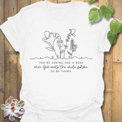 White t-shirt featuring the design Asking For A Rose printed in black letters and flowers, floral humour shirt.