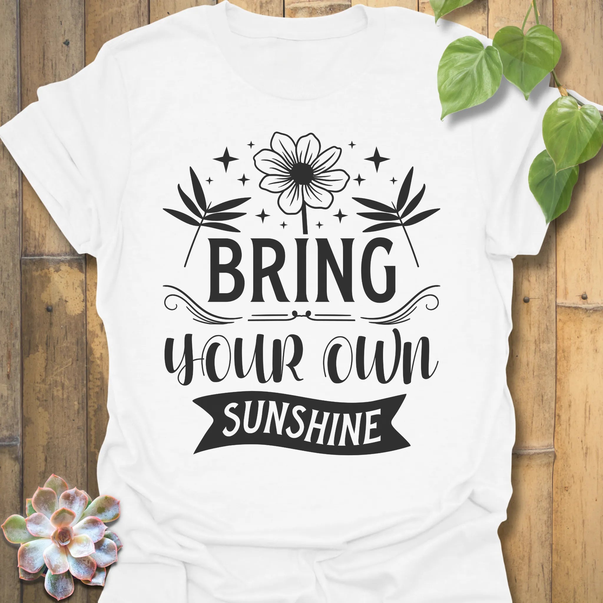 White t-shirt featuring the design Bring Your Own Sunshine printed in bold black letters, positive vibes shirt.