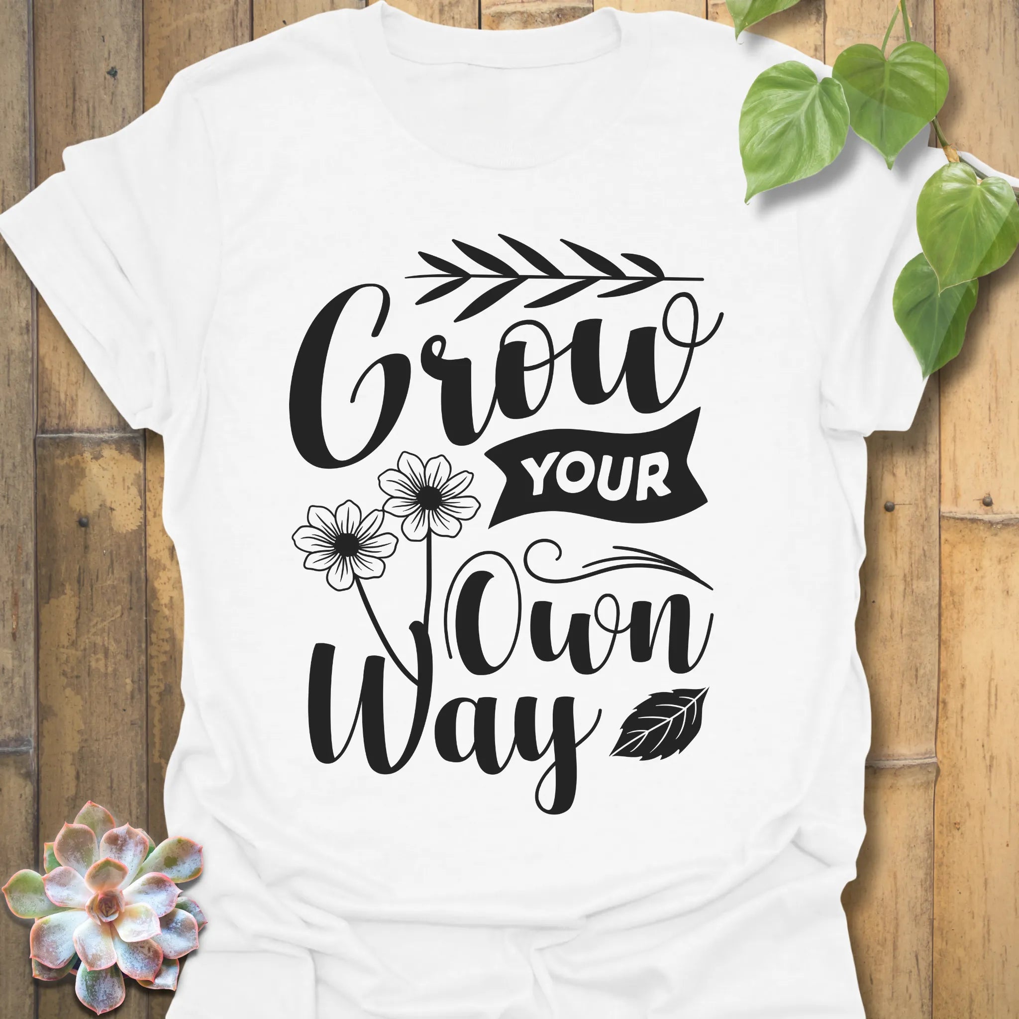 White t-shirt featuring the design Grow Your Own Way printed in bold black letters, positive garden shirt.