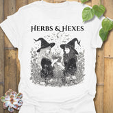 White t-shirt featuring the design Herbs & Hexes printed in bold black letters, botanical witch t-shirt.