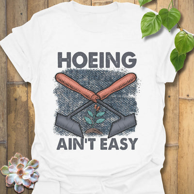White t-shirt featuring the design Hoeing Ain’t Easy, funny gardening shirt.