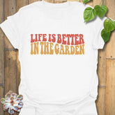 White t-shirt featuring the design Life is better in the garden printed in green floral lettering, perfect gardening shirt for plant lovers.