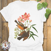 White t-shirt with the Spring Songbirds design showing two detailed birds perched near pink blossoms and leafy branches